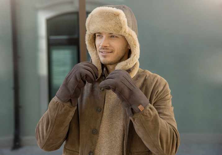 Mann mit Alpakafellmütze und Handschuhen